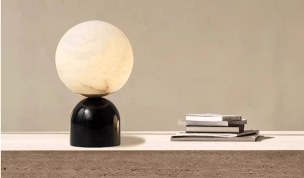 Round alabaster table lamp placed on a marble surface